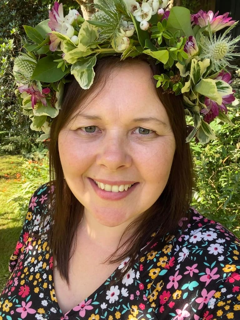 Louisa wearing a flower crown standing in the garden